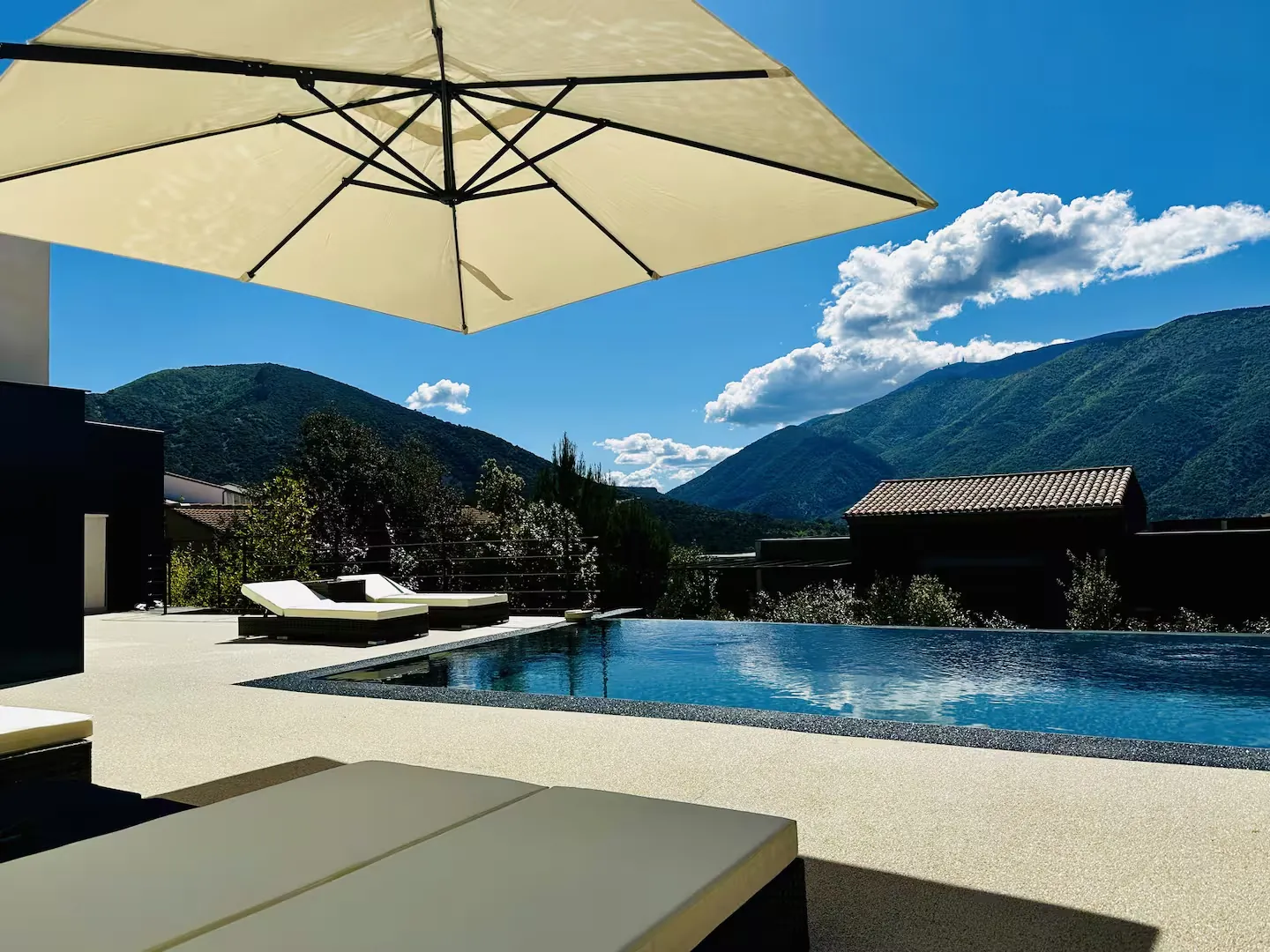 Piscine sous le parasol, vue sur les montagnes